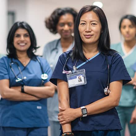 4 nurse leaders wearing medical scrubs and stethoscopes. 