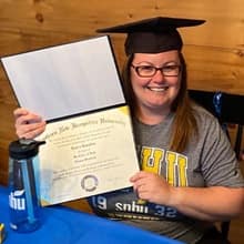 Laura Gaughan holding her SNHU diploma and wearing a graduation cap.