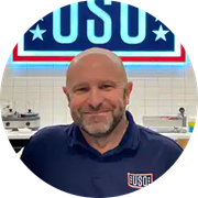 Military veteran, SNHU graduate and Massachusetts resident Michael Shimkus in front of a USO banner.