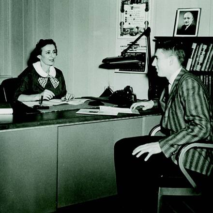Gertrude Shapiro speaking with a student in her office.
