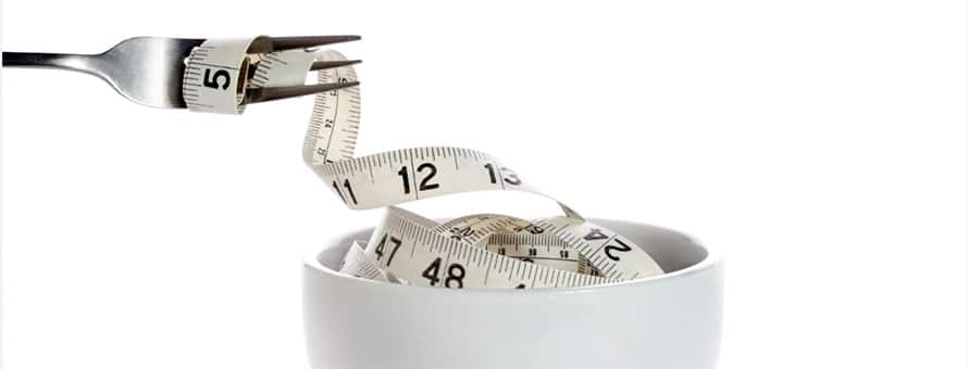 A fork taking a fabric measuring tape out of a bowl