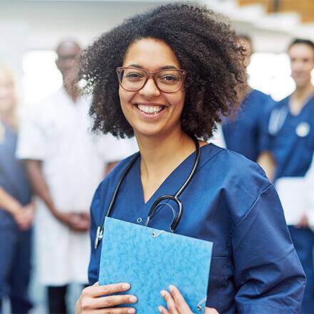 A nurse with a stethoscope and clipboard surrounded by four other healthcare professionals.