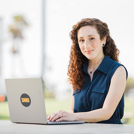 SNHU student on her laptop smiling