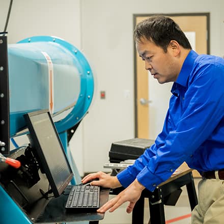 An aeronautical engineer working on a computer in a lab.