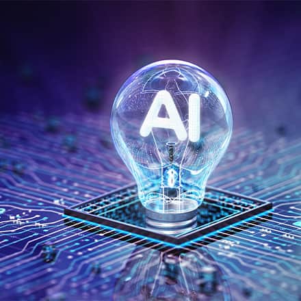 A lightbulb that says "AI" in the center screwed in a purple, blue and black circuit board.