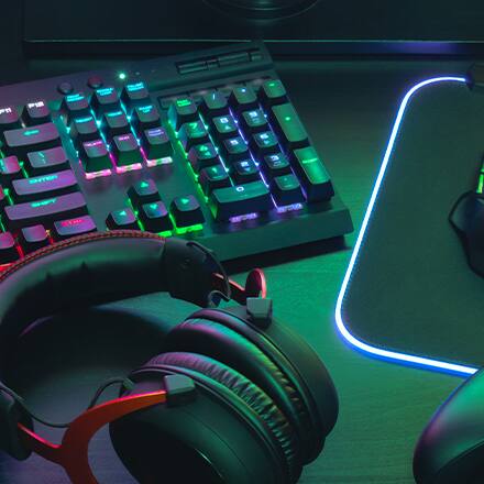 A LED keyboard, mouse and headset on a game developer’s desk