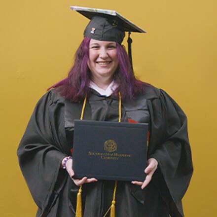 Amber Bownan, an associate in liberal arts and bachelor's in general studies graduate from SNHU wearing her cap and gown in front of a yellow background.