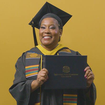 Andrinna Broadnax '25, bachelor's in public health graduate from SNHU, holding her diploma.