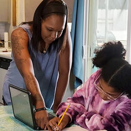 Latisha Aguilar '21, who earned a bachelor’s degree in psychology with a concentration in child and adolescent development, helping her daughter with homework.