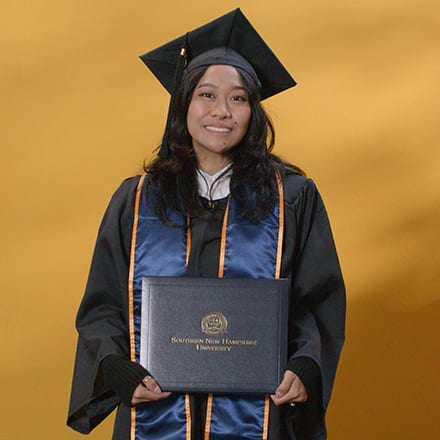 Carlene Estigoy, an SNHU graduate with a bachelor's in psychology, wearing a graduation cap and gown
