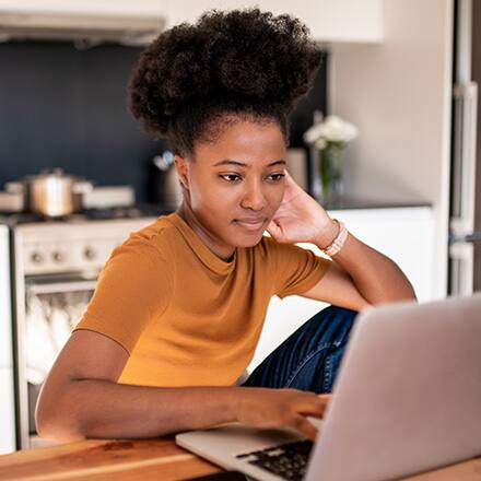 A female student sitting at a table working on her laptop
