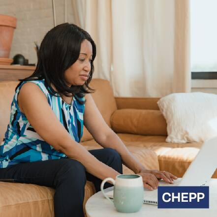 A woman working on her laptop in her living room.