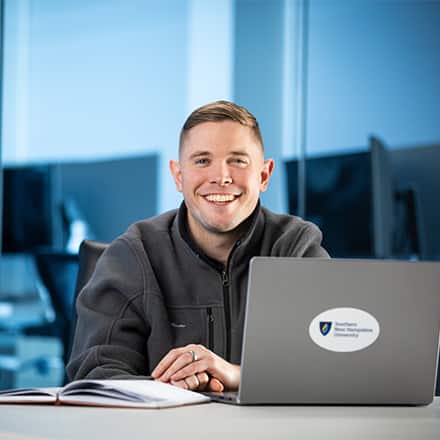 Rob Thomas '24, SNHU graduate with a bachelor's in general studies, studying on his laptop.