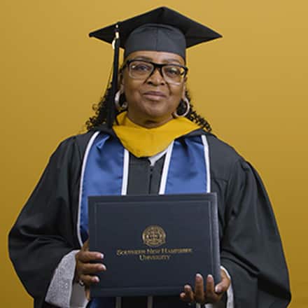 Cynthia Preston dressed in a graduation cap and gown after earning her bachelor's in marketing at SNHU in 2026.