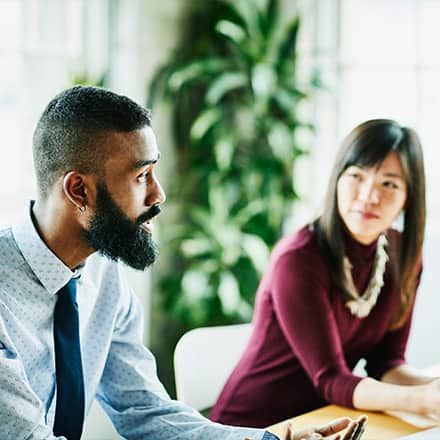 A person practicing empathy in the workplace as she listens to her colleague.