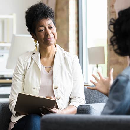 A psychiatrist speaking to a patient in their office.
