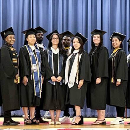 A number of SNHU graduates in caps, gowns and regalia at Fort Campbell's combined colleges ceremony.