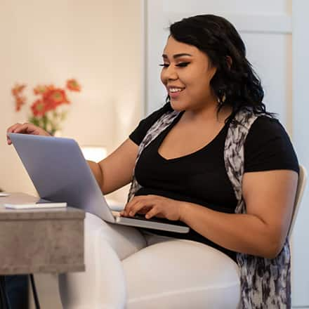 An adult learner discovering how online courses work, sitting at a desk with a laptop.