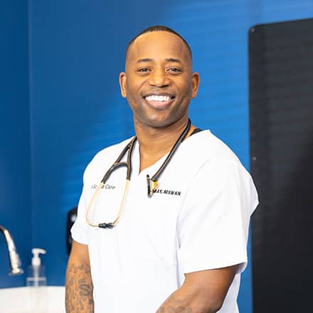 Anthony Gray, an SNHU graduate with a Master of Science in Nursing, dressed in white scrubs with a stethoscope around his neck.