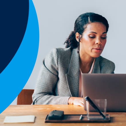 An accountant pointing to her laptop to show an accounting degree major information about the career field.