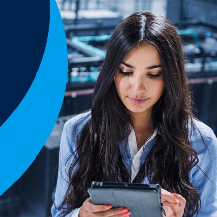 A woman using a tablet to pursue an online cybersecurity degree