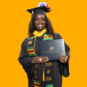 Kendreka Griffin, a 2024 SNHU graduate who earned her bachelor's in business administration, wearing her cap and gown in front of a yellow background, holding her diploma.