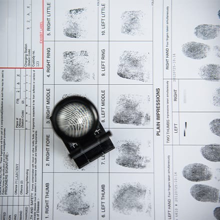 A fingerprint form with a magnifying glass.