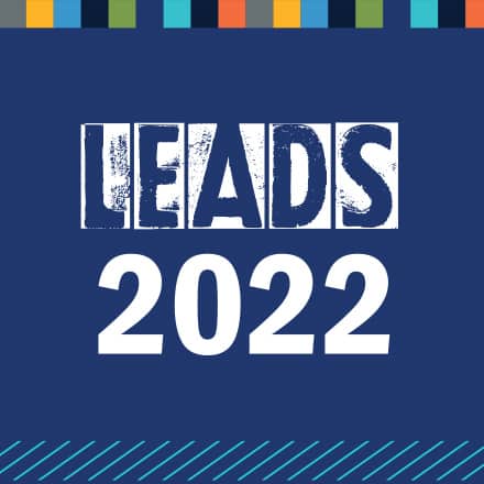 A blue graphic with multicolored boxes across the top and a diagonal line pattern on the bottom with the text LEADS 2022