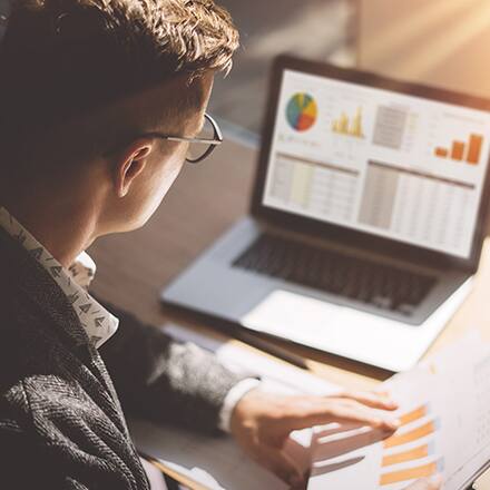 A person sitting at a desk working on an accounting course on their laptop