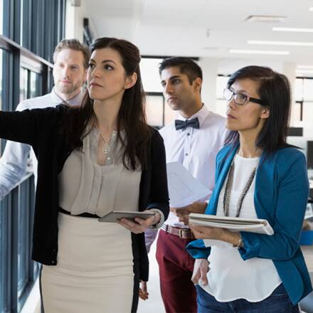 Business professionals discussing the advantages of an online master's in organizational leadership 