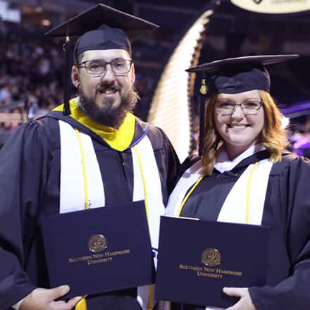 Michael and Taria Richards holding their diplomas at the SNHU graduation