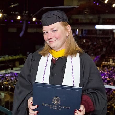 Michelle Nachand, an SNHU nursing graduate with a BSN and MSN, dressed in a cap and gown at her graduation ceremony.