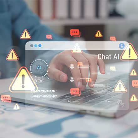A person on their laptop surrounded by warning icons to represent AI misinformation and disinformation.