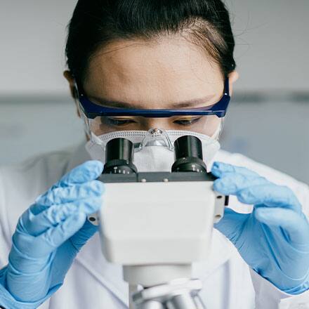 A doctor looking into a microscope