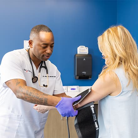 SNHU alum, Anthony Gray '21, who earned an MSN degree, taking a patient's blood pressure.