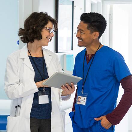 Two healthcare professionals with different types of master’s degrees discussing a chart in a healthcare facility.