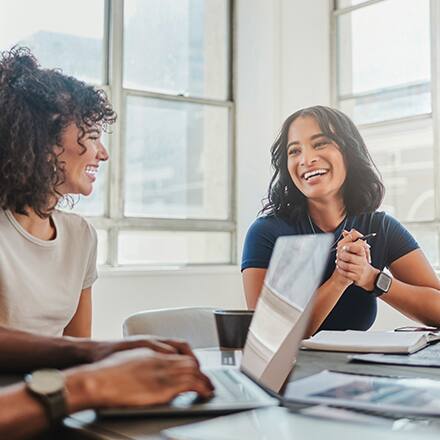 Two business professionals sitting at a table and discussing types of MBA concentrations.
