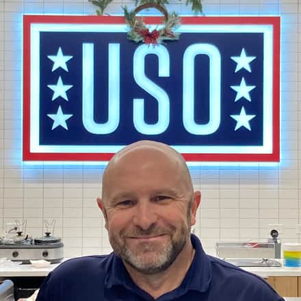 Michael Shimkus in front of a USO banner
