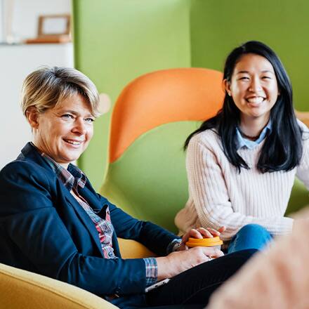 Two professionals learning what MBA stands for as they sit in a business meeting