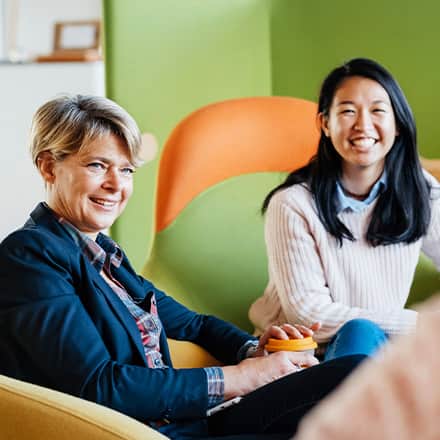 Two professionals learning what MBA stands for as they sit in a business meeting.