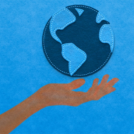 Graphic treatment of a hand holding the earth on a blue background