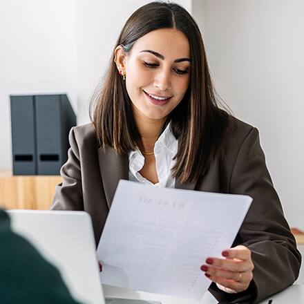 A woman sitting at a table going over her resume with an advisor