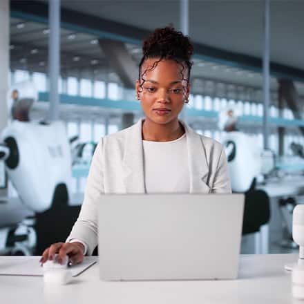 A woman working in a robotics lab, representing automation and AI replacing jobs in the workforce.