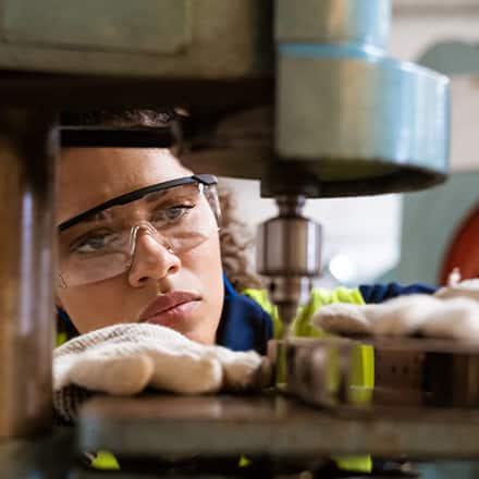 A mechanical engineer wearing protective equipment while working with machinery.
