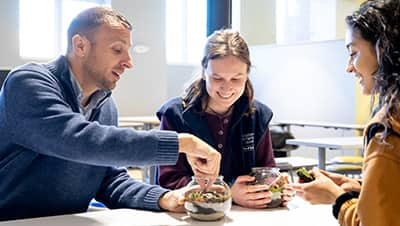 Three professionals engaging in a team-building activity at a table.