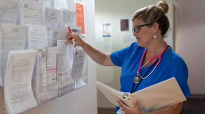 A nurse looking at medical documents.