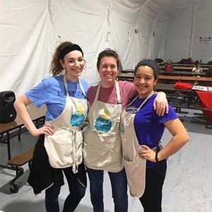 Three women wearing tan aprons working with the homeless population in Washington, D.C.