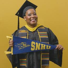 Andrinna Broadnax '25, bachelor's in public health graduate from SNHU, holding an SNHU pennant.