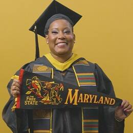 Andrinna Broadnax '25, bachelor's in public health graduate from SNHU, holding a Maryland state pennant.