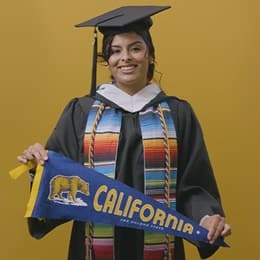Angel Delatorre, BA in Psychology graduate from SNHU and U.S. Army veteran, holding California state flag.